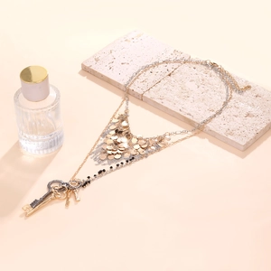 Collier bohème à plusieurs rangs avec paillettes et pendentifs clés sur fond de pierre