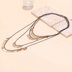 Collier bohème à trois rangs de perles avec de longs pendentifs en tubes métalliques dorés