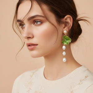 Baroque pearl earrings with green enamel floral leaves on model for stylish look