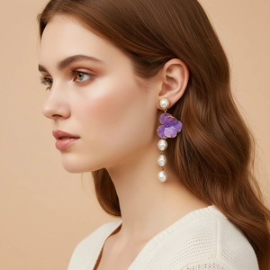 Baroque pearl earrings with purple enamel flower drop on a model showing side profile view