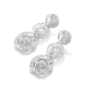 Detailed macro of silver spiral concentric circle drop earrings with a metallic finish