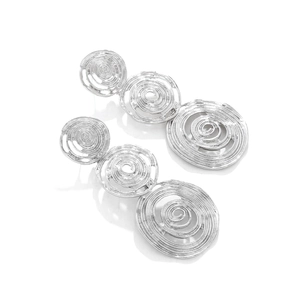 Macro detail of silver tiered spiral earrings featuring geometric concentric circle texture
