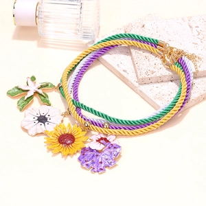 Detail of colorful woven ropes with enamel sunflower and tropical leaf pendants