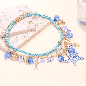 Multilayer ocean themed necklace with starfish and shell pendants on stone background