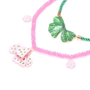 Detail of pink beaded and green cord necklaces with enamel flower and leaf pendants