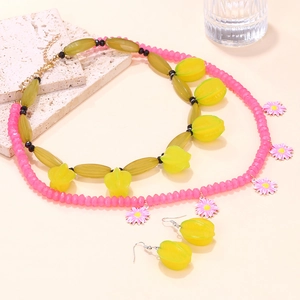 Detail of layered beaded necklace with pink daisy and yellow starfruit charms set