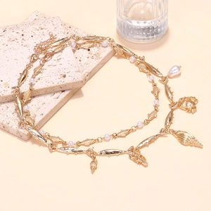 Double-layered gold necklace with tropical fish, crab, and shells charms and pearls