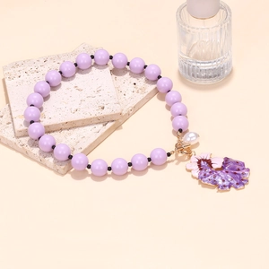 Bohemian purple beaded necklace featuring a floral enamel pendant and pearl detail
