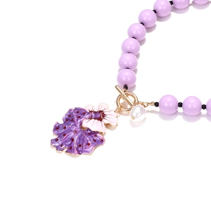 Detail of purple beaded necklace with flower pendant, pearl accent and golden OT buckle