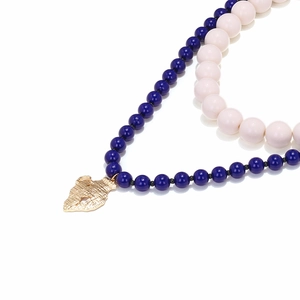 Collana a strati con perline blu scuro e un ciondolo a forma di giara dorata