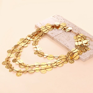Vintage multi-layer gold layered necklace with hammered metal discs on textured stone