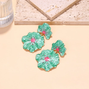 Detail of green enamel leaf earrings with pink star motif and gold metal edges