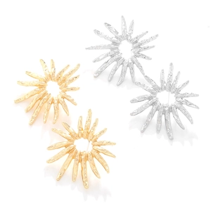 Detail of gold and silver sunburst textured stud earrings with hammered finish