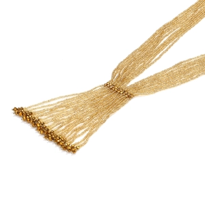 Detailed macro view of gold multi-strand beaded tassel necklace with metallic finish