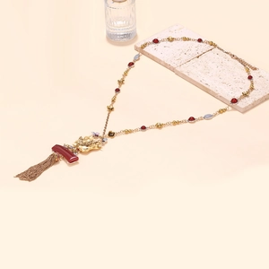 Detailed view of vintage gold necklace with dragon head pendant and metallic tassels