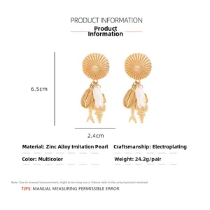 Detail goldene Ohrhänger mit Barockperle, Meeresfisch und Muschel-Anhängern