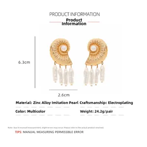 Detail view of gold conch earrings featuring baroque pearls and shell texture