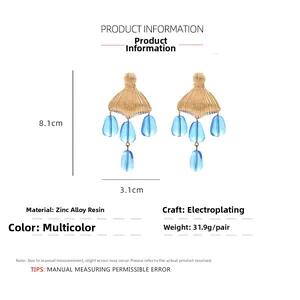 Detailed specs of fishtail earrings made of gold-plated zinc alloy and blue resin beads