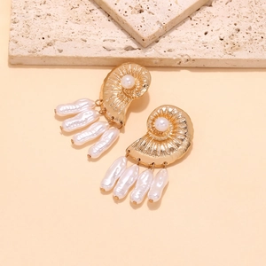 Detailed shot of golden sea shell earrings with elegant baroque pearl pendants
