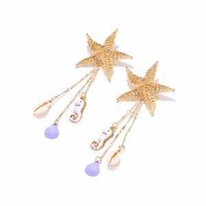 Detail of gold starfish earrings with seahorse shell charms and long tassels