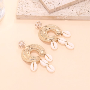 Bohemian C-shaped gold textured earrings with white pearls and hanging cowrie shells