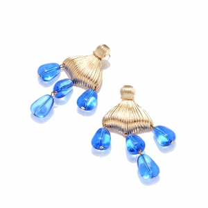 Detail of fishtail beaded earrings featuring gold fan studs and blue teardrop beads