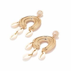 Detailed close-up of Bohemian gold textured C-shaped earrings with shell and pearl accents