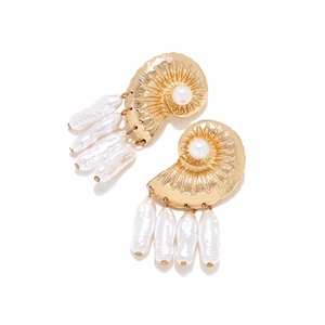 Detail view of golden conch shell earrings with white baroque pearl pendants and fine texture