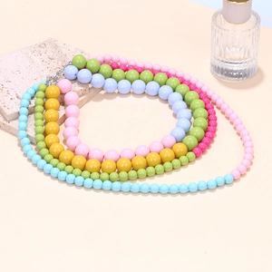 Close-up of layered macaron bead necklaces with colorful waterfall design and silver clasp