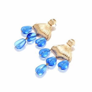 Close-up of golden fishtail earrings featuring handcrafted royal blue beaded charms