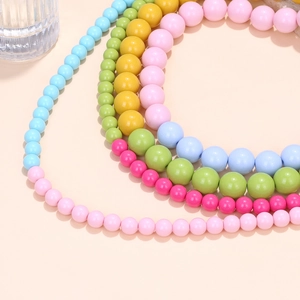 Close-up of vibrant candy-colored beaded necklaces in pastel blue pink yellow and green