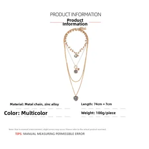 Detail of multi-layer gold metal necklace with heart pendants and crystal accents