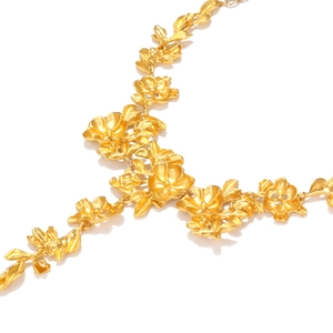Vintage style golden floral statement necklace with textured 3D flower petals on white background