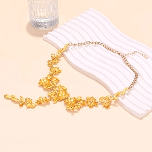 Detailed view of the layered gold floral pendant necklace and metal leaf textures