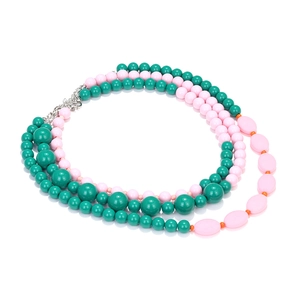 Macro detail of multilayer macaron bead necklace showing green and pink resin pearls
