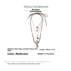 Detail view of multi-layered long necklace with faux pearls and vintage coin pendants