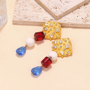 Close-up of resin drop earrings with gold alloy base and colorful bead detail