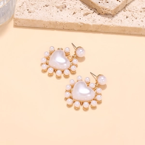 Détail de boucles d'oreilles en perles en forme de cœur avec petits clusters de perles