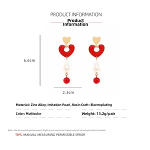 Detailed view of red heart enamel baroque pearl drop earrings with 6.6cm dimensions