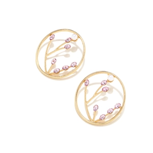 Detail of vintage gold hoop earrings with purple stones and pearls in floral branch design