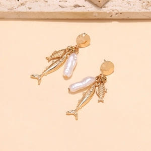 Detailed view of long gold fish drop earrings with baroque pearl and golden discs