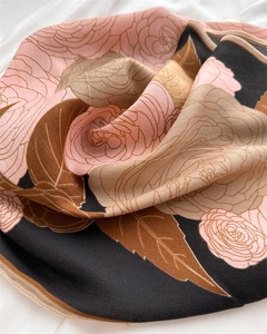 Detailed view of the herringbone texture and camellia floral pattern on the silk scarf