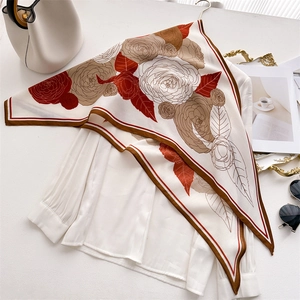 Elegant herringbone camellia silk scarf for women displayed on a white shirt