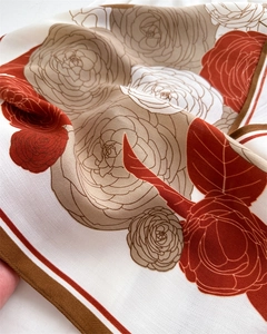 Detailed macro view of camellia floral print and herringbone silk texture on this scarf