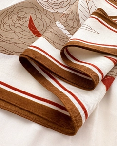 Close-up of camellia pattern scarf showing detailed herringbone texture and rolled edges