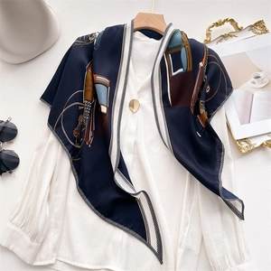 Elegant navy silk-feel scarf with carriage pattern and geometric prints on white background