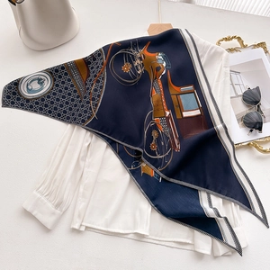 Navy blue velvet scarf with vintage carriage print and geometric borders over a white shirt