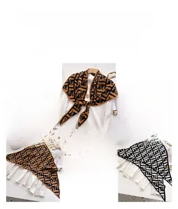 Detail view of velvet shawl with classic geometric letter print and silk-like texture