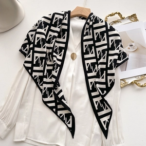 Elegant black and white geometric velvet triangle scarf styled on a white shirt with hanger