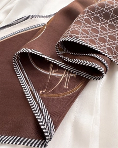 Detail of herringbone velvet shawl with geometric diamond patterns and luxury trim